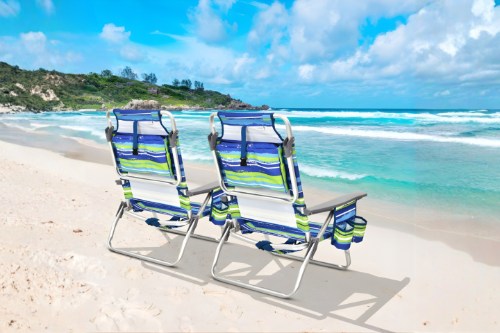 Two striped beach chairs facing ocean under blue sky.